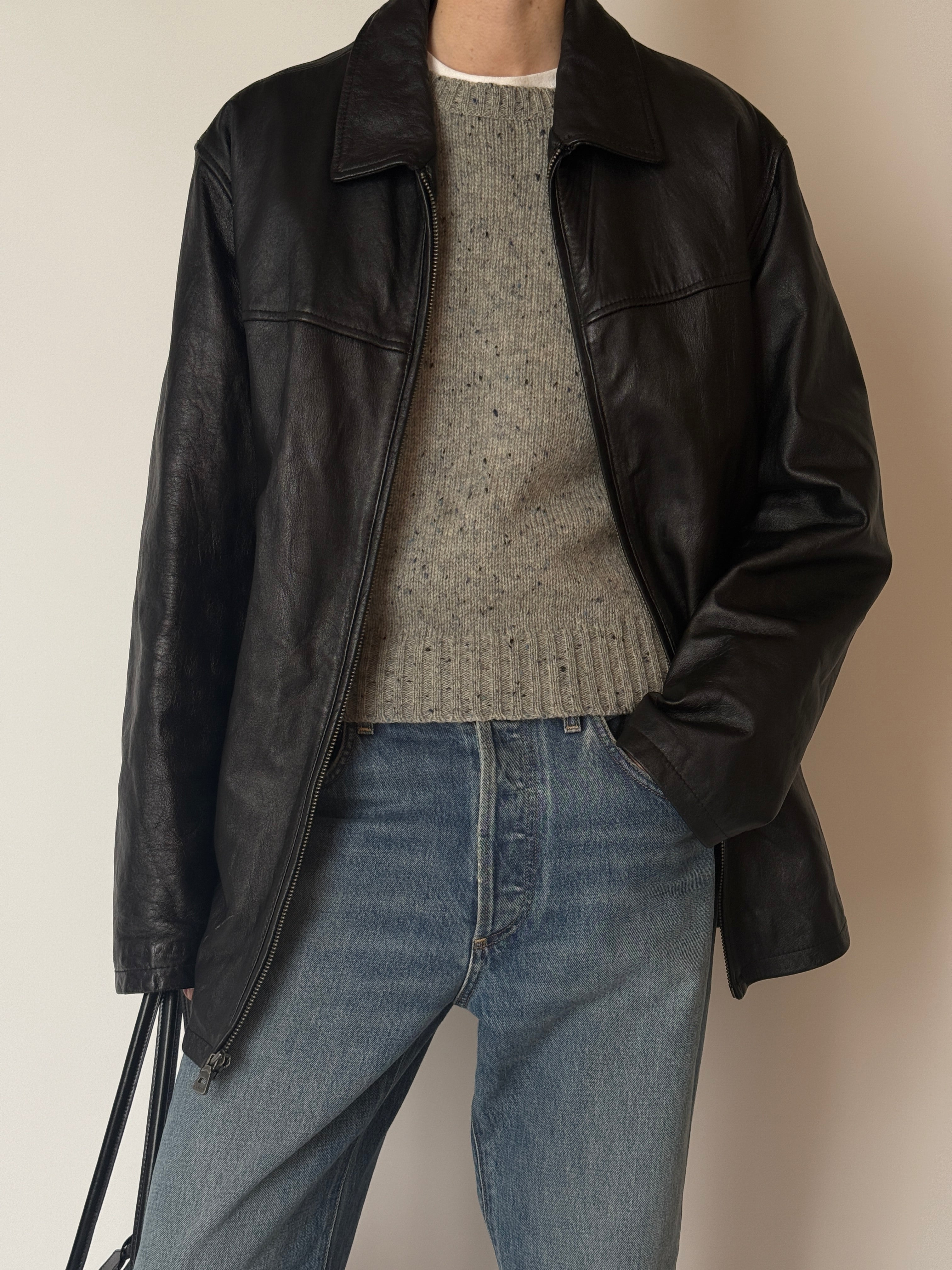 Close-up of vintage black leather jacket texture and stitching