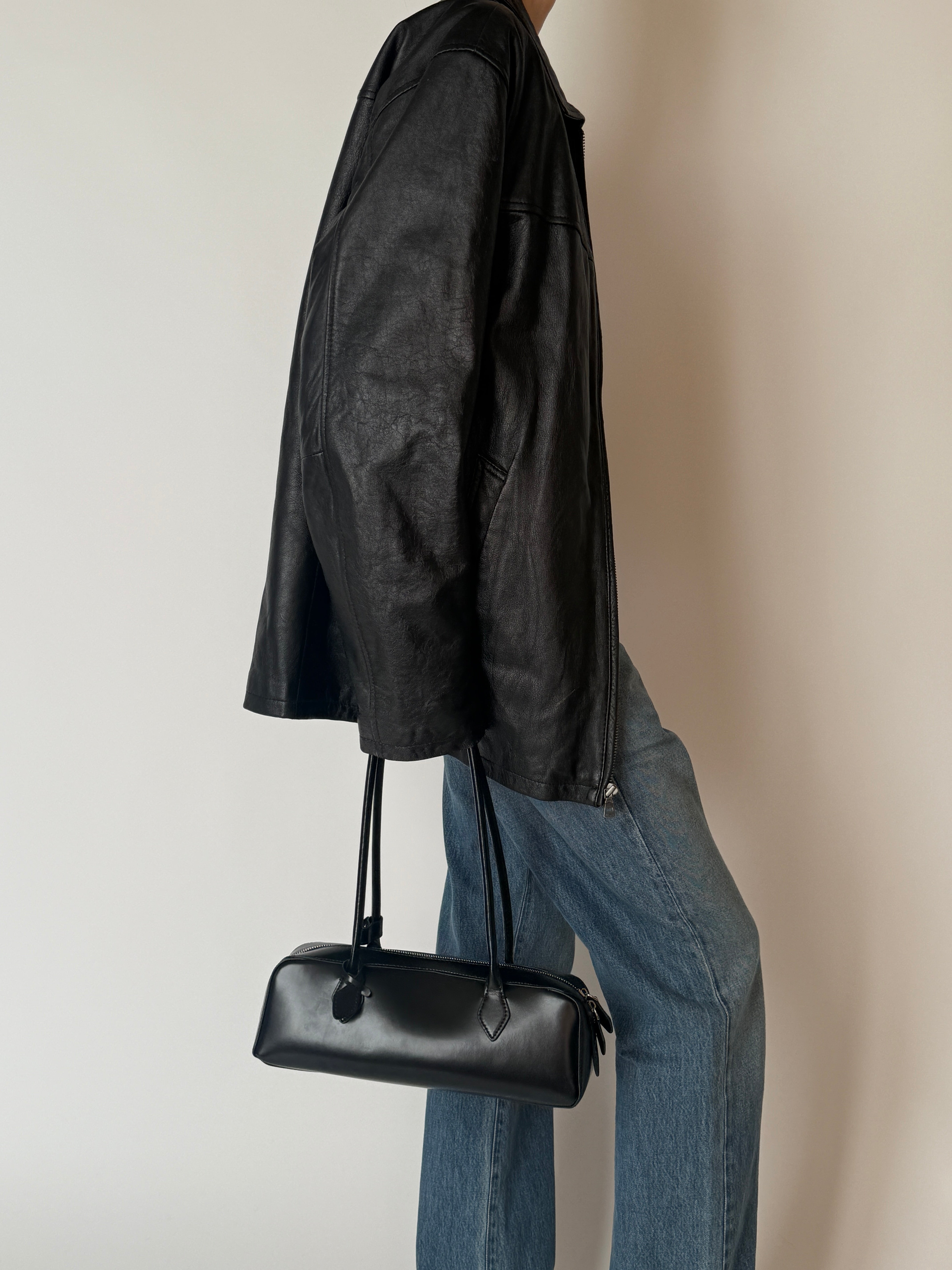 Close-up of vintage black leather jacket texture and stitching side