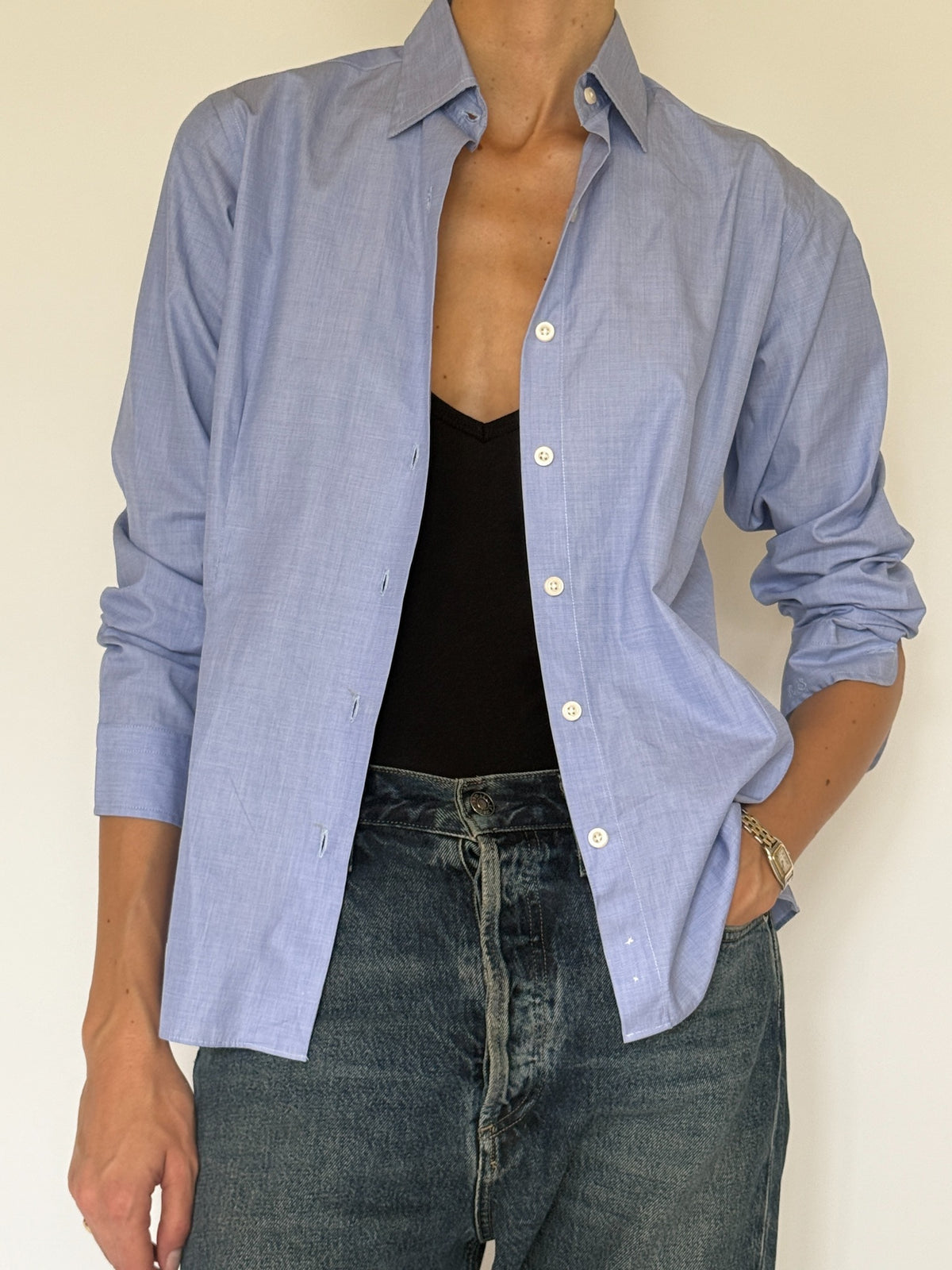 Close front view of light blue shirt with pointed collar and white buttons