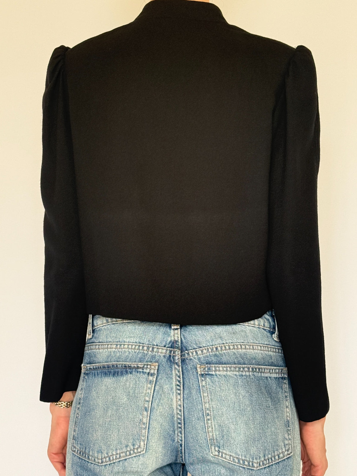 Vintage black wool jacket close-up showing structured front and puff shoulder detail