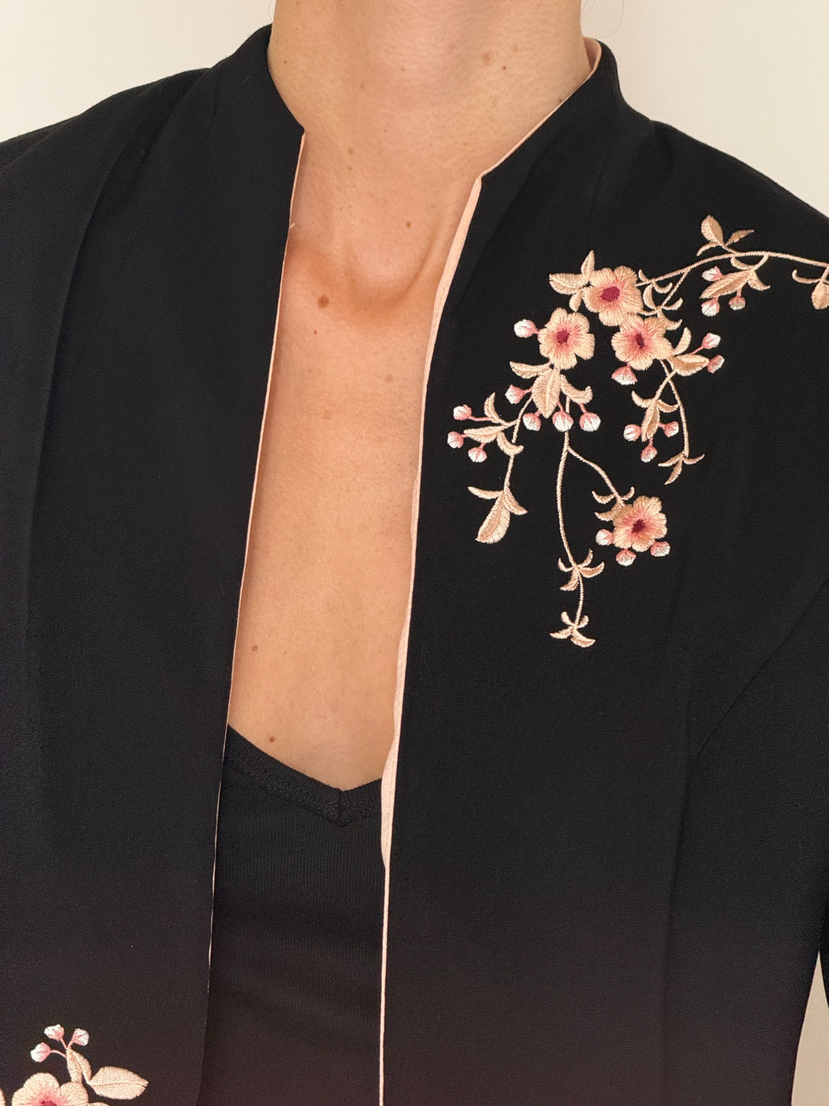 Vintage embroidered open-front jacket black floral fabric close-up