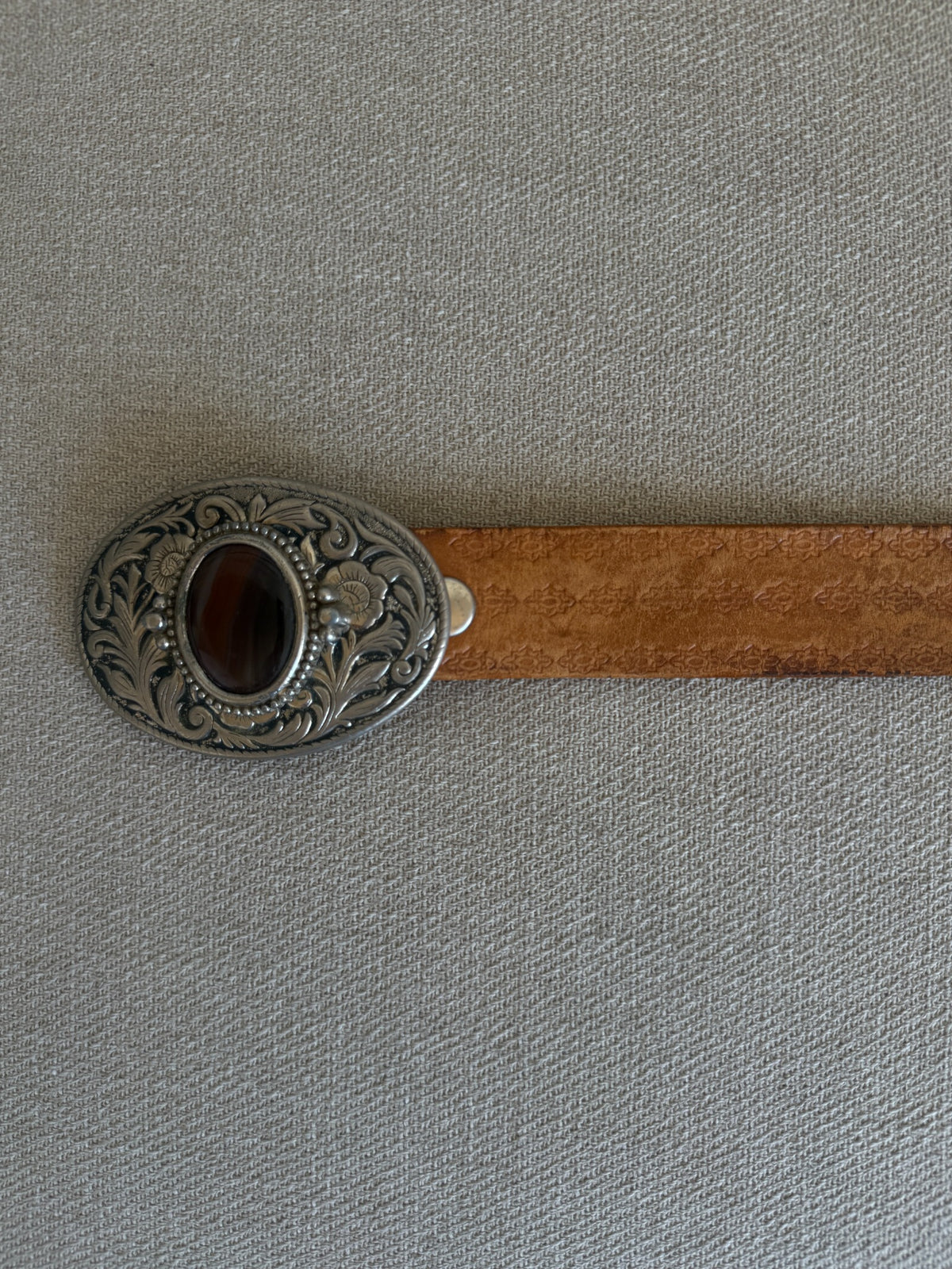 Vintage western belt brown laid flat with ornate oval buckle